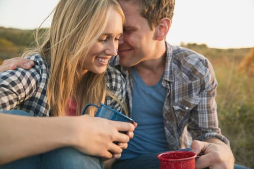 飲み物を片手に、もう片方の手で女性を抱き寄せ顔を近づける男性